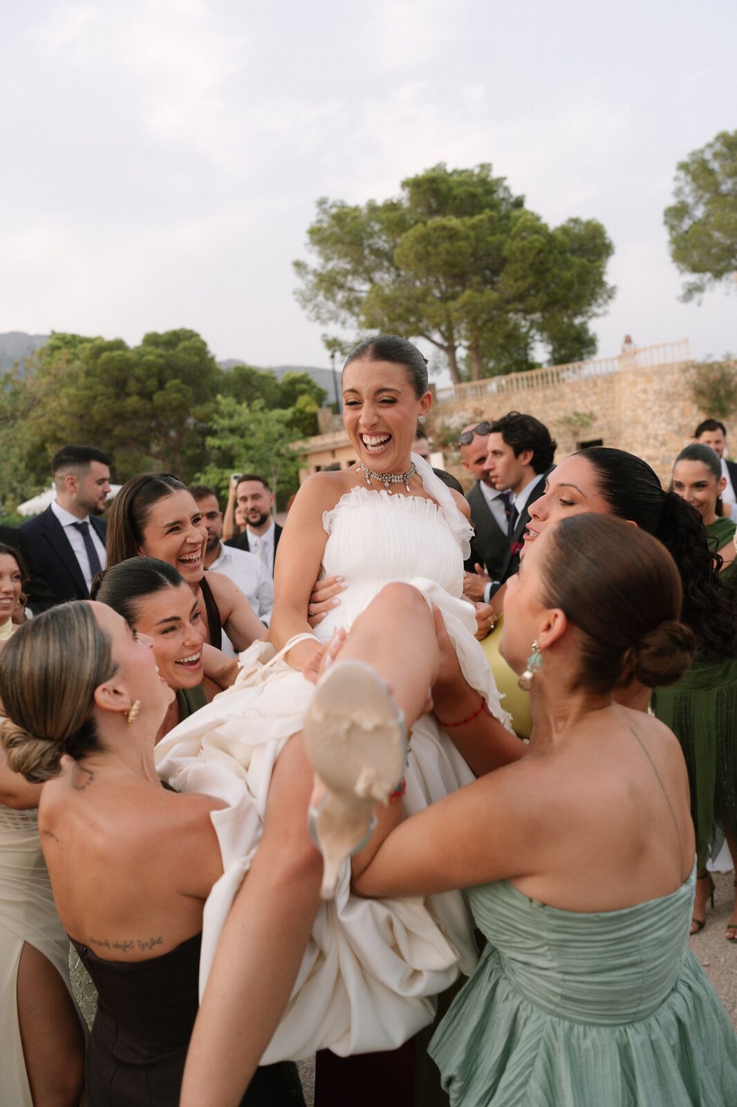 La novia en brazos de sus amigas, riendo